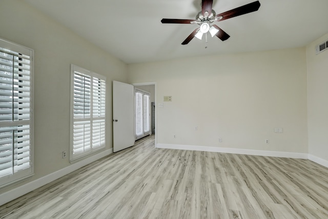 empty room with ceiling fan and light hardwood / wood-style flooring