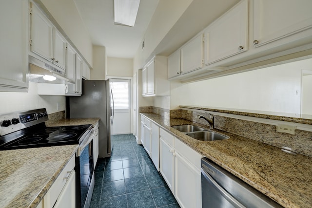 kitchen featuring dark tile patterned flooring, sink, white cabinetry, stainless steel appliances, and light stone counters