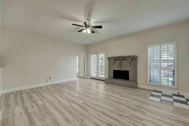 unfurnished living room with a fireplace, ceiling fan, and light wood-type flooring