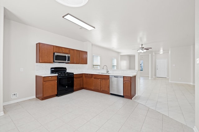 kitchen featuring stainless steel appliances, kitchen peninsula, sink, tasteful backsplash, and ceiling fan