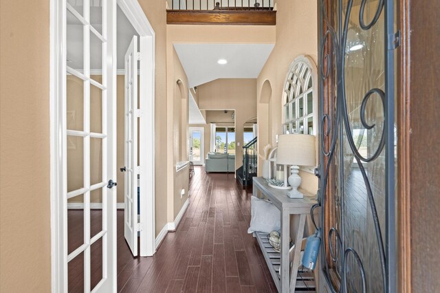 entryway featuring lofted ceiling, dark wood-type flooring, and french doors