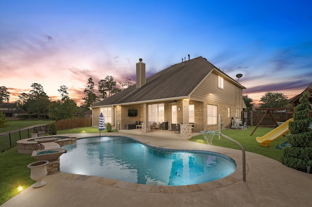 view of swimming pool featuring an in ground hot tub, a patio, a playground, and a yard