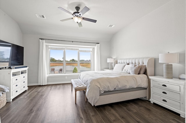 bedroom featuring dark wood-type flooring, ceiling fan, a water view, and vaulted ceiling