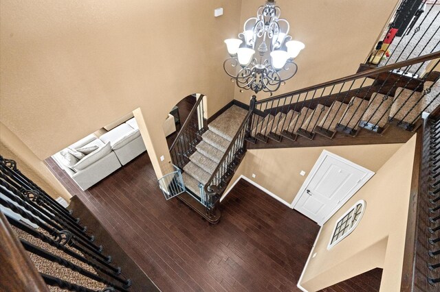 stairway with a notable chandelier and wood-type flooring