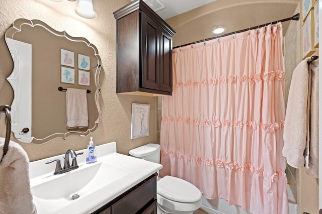 full bathroom featuring vanity, shower / bath combo, and toilet