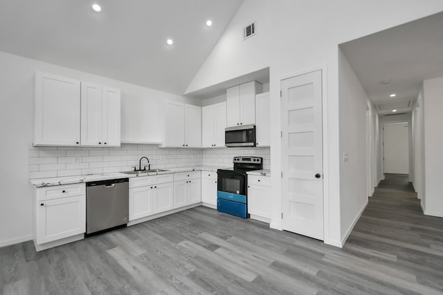 kitchen featuring white cabinetry, sink, light wood-type flooring, and appliances with stainless steel finishes