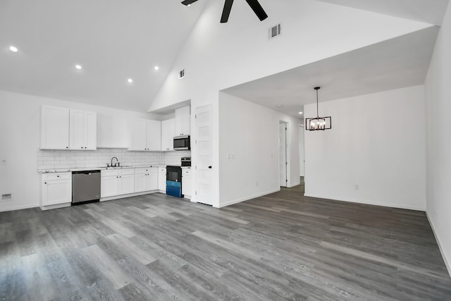 kitchen with hardwood / wood-style flooring, white cabinetry, appliances with stainless steel finishes, backsplash, and decorative light fixtures