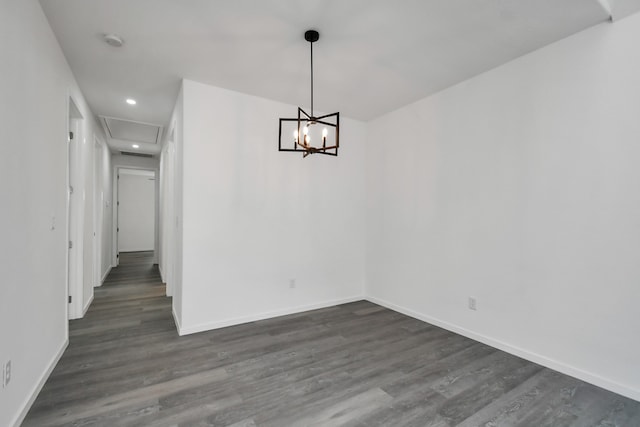 unfurnished dining area featuring dark hardwood / wood-style flooring and an inviting chandelier