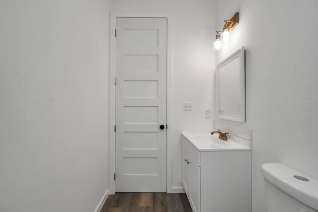 bathroom featuring wood-type flooring, vanity, and toilet