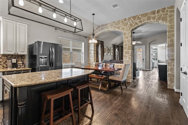 kitchen with ceiling fan, tasteful backsplash, decorative light fixtures, a kitchen island, and fridge with ice dispenser