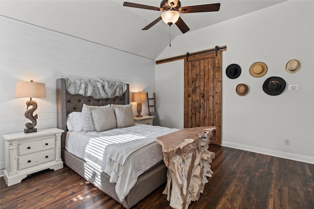 bedroom with a barn door, dark hardwood / wood-style floors, vaulted ceiling, and ceiling fan