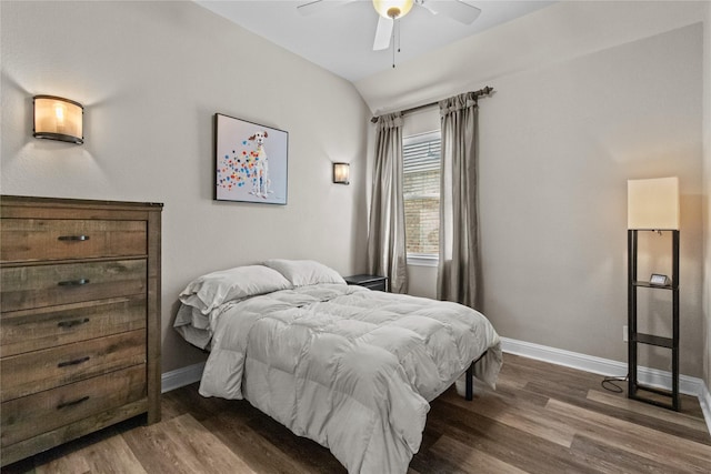 bedroom featuring dark hardwood / wood-style floors, vaulted ceiling, and ceiling fan