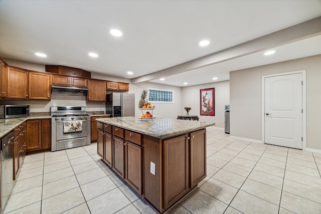 kitchen with light tile patterned flooring, light stone countertops, a kitchen island, and stainless steel appliances