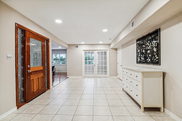 foyer entrance featuring light tile patterned flooring and french doors