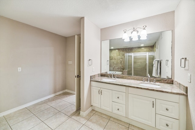 bathroom featuring tile patterned floors, vanity, walk in shower, and a textured ceiling