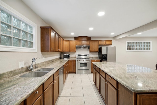 3227 Audley St, Houston, TX 77098 - kitchen featuring appliances with stainless steel finishes, light tile patterned flooring, recessed lighting, a kitchen island, and light stone countertops