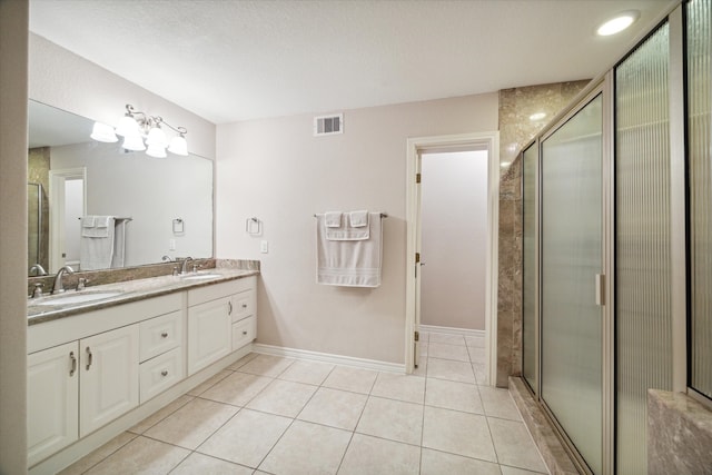 bathroom featuring tile patterned flooring, a textured ceiling, vanity, and a shower with shower door