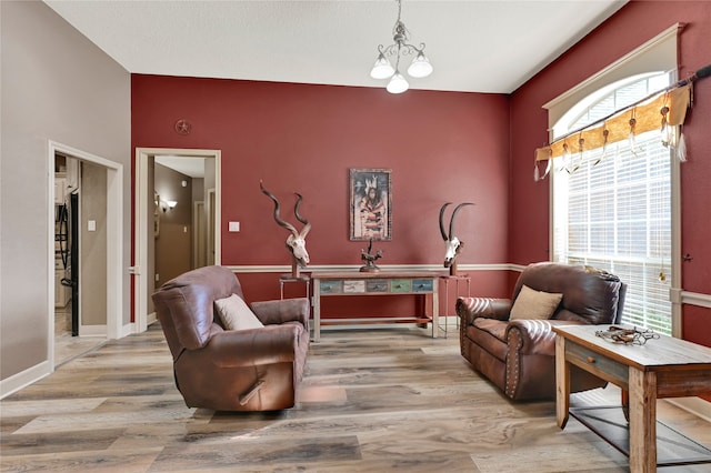 living area with a healthy amount of sunlight, a notable chandelier, and light hardwood / wood-style floors