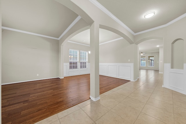 empty room with ceiling fan, ornamental molding, and light hardwood / wood-style flooring