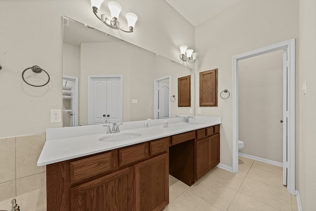 bathroom with vanity, vaulted ceiling, toilet, and tile patterned floors