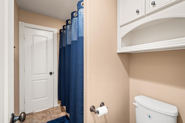 bathroom featuring toilet, walk in shower, and tile patterned flooring