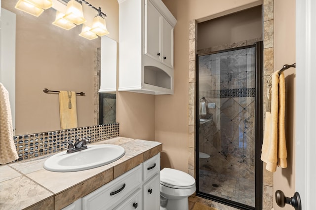 bathroom featuring vanity, walk in shower, toilet, and tasteful backsplash