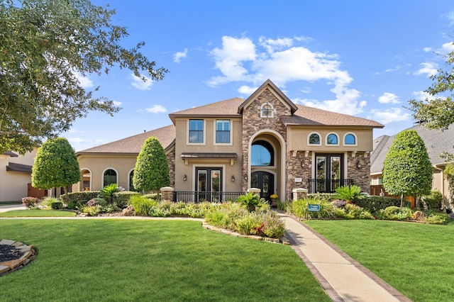 mediterranean / spanish home with french doors and a front lawn