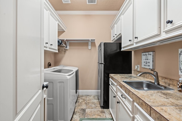 clothes washing area featuring crown molding, a textured ceiling, sink, and washer and clothes dryer