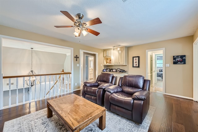 living room featuring hardwood / wood-style floors and ceiling fan with notable chandelier