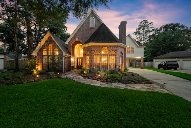 view of front of property with a lawn, an outbuilding, and a garage