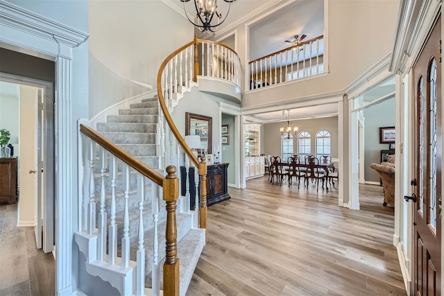 entrance foyer featuring a towering ceiling, an inviting chandelier, and light hardwood / wood-style floors