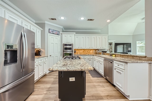 kitchen with light stone countertops, appliances with stainless steel finishes, light hardwood / wood-style flooring, and kitchen peninsula