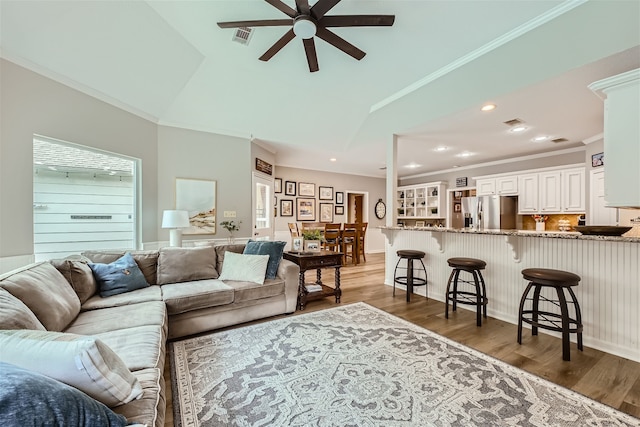 living room featuring ornamental molding, lofted ceiling, dark hardwood / wood-style floors, and ceiling fan