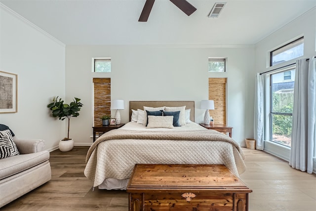 bedroom featuring crown molding, light hardwood / wood-style flooring, and ceiling fan