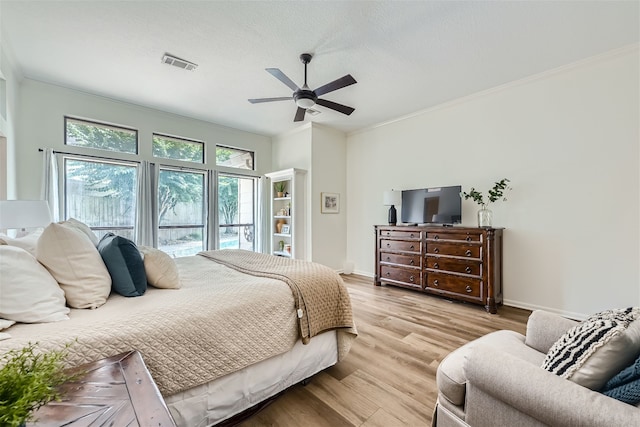 bedroom featuring ceiling fan, ornamental molding, a textured ceiling, and light wood-type flooring