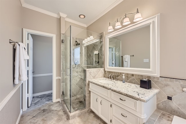 bathroom with vanity, a shower with shower door, and ornamental molding