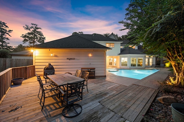 pool at dusk featuring a deck