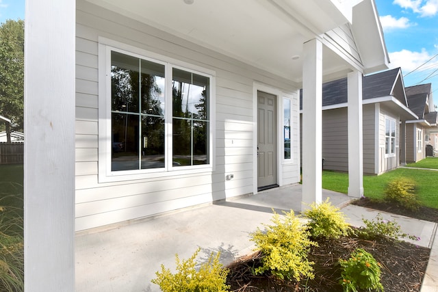 view of exterior entry featuring covered porch