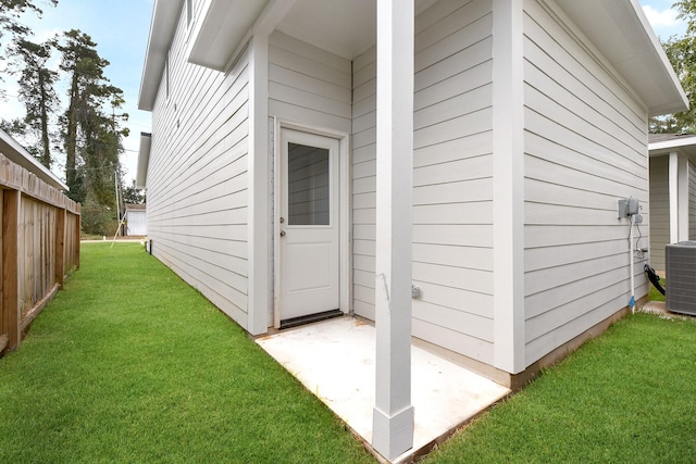 view of home's exterior featuring fence, cooling unit, and a yard