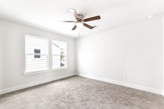 unfurnished room with carpet flooring, ceiling fan, visible vents, and baseboards