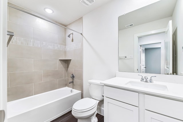 full bathroom with hardwood / wood-style floors, vanity, toilet, and tiled shower / bath