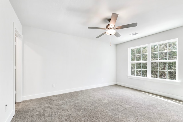 carpeted spare room featuring ceiling fan