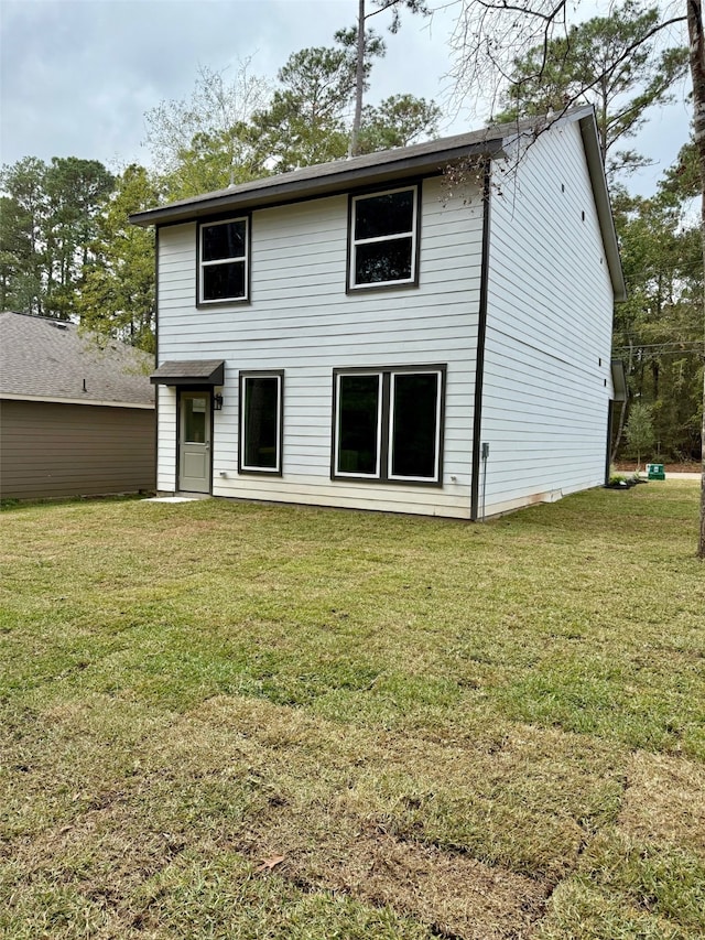 rear view of house featuring a lawn