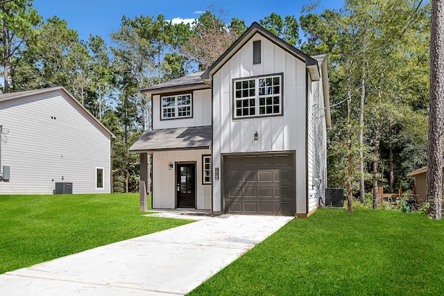 view of front of property featuring central AC unit, a garage, and a front lawn