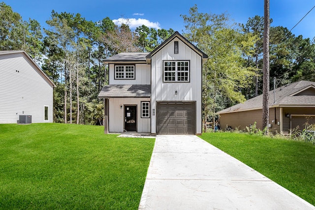 view of front of house featuring a garage, cooling unit, and a front lawn