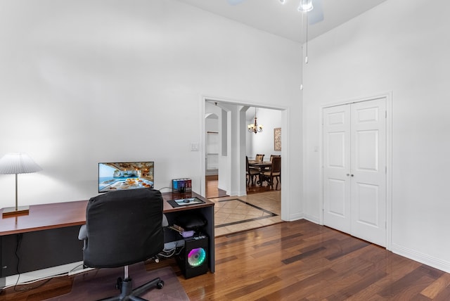 office area with hardwood / wood-style flooring, a high ceiling, and an inviting chandelier