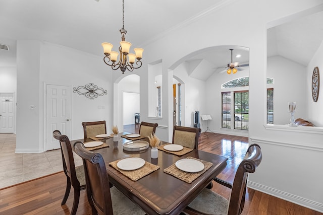 dining space featuring crown molding, vaulted ceiling, light wood-type flooring, and ceiling fan with notable chandelier