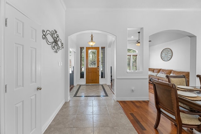 foyer entrance featuring crown molding, light hardwood / wood-style floors, and ceiling fan