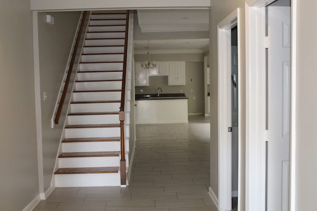 stairs featuring crown molding and sink