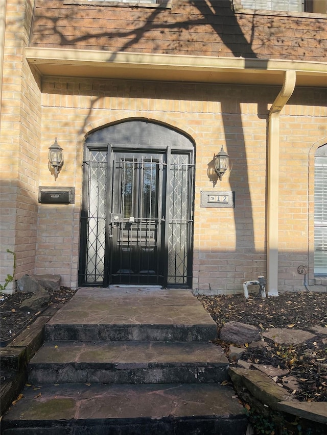 property entrance with brick siding and roof with shingles